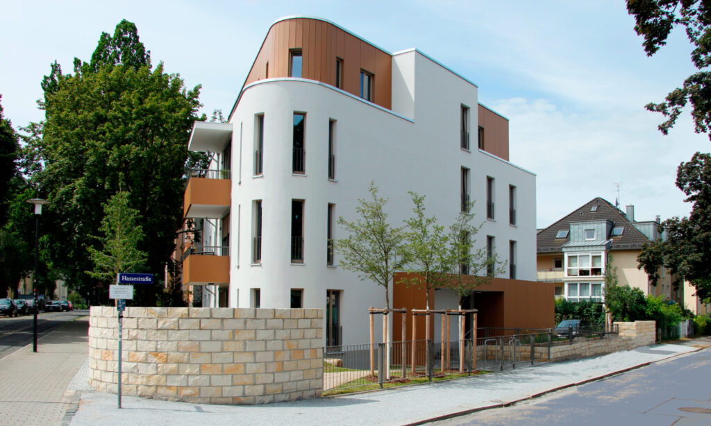 Ein Mehrfamilienhaus an einer Straßenecke mit gerundeter Fassade